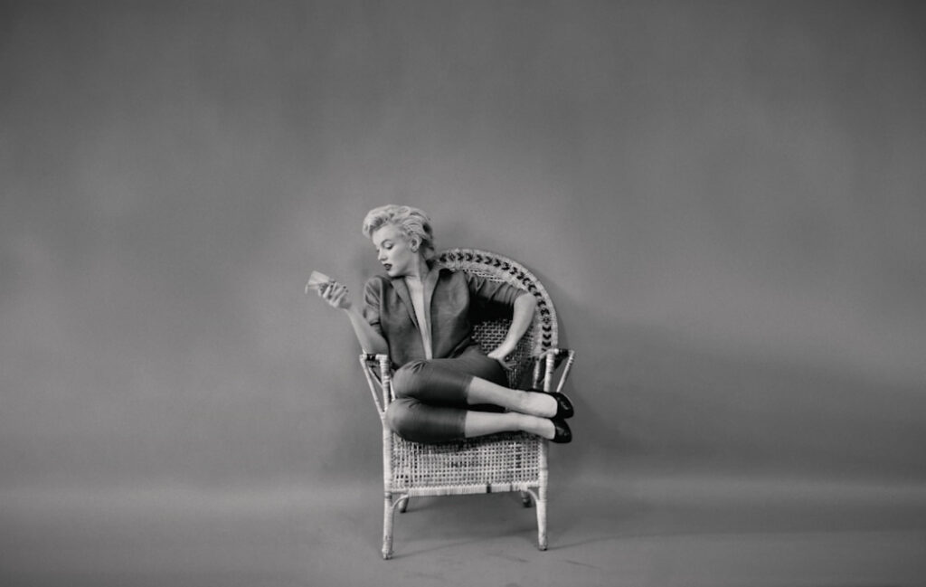 Portrait of Marilyn Monroe sitting alone on a wicker chair